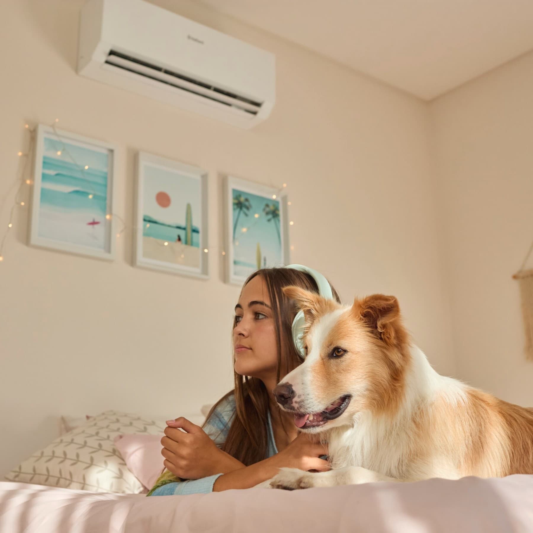 Ragazza con cane sul letto. Sullo sfondo, climatizzatore Vaillant.