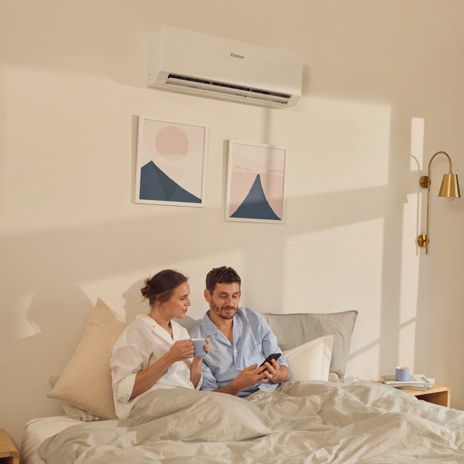 Coppia in camera da letto con unità interna del climatizzatore Vaillant installata a parete