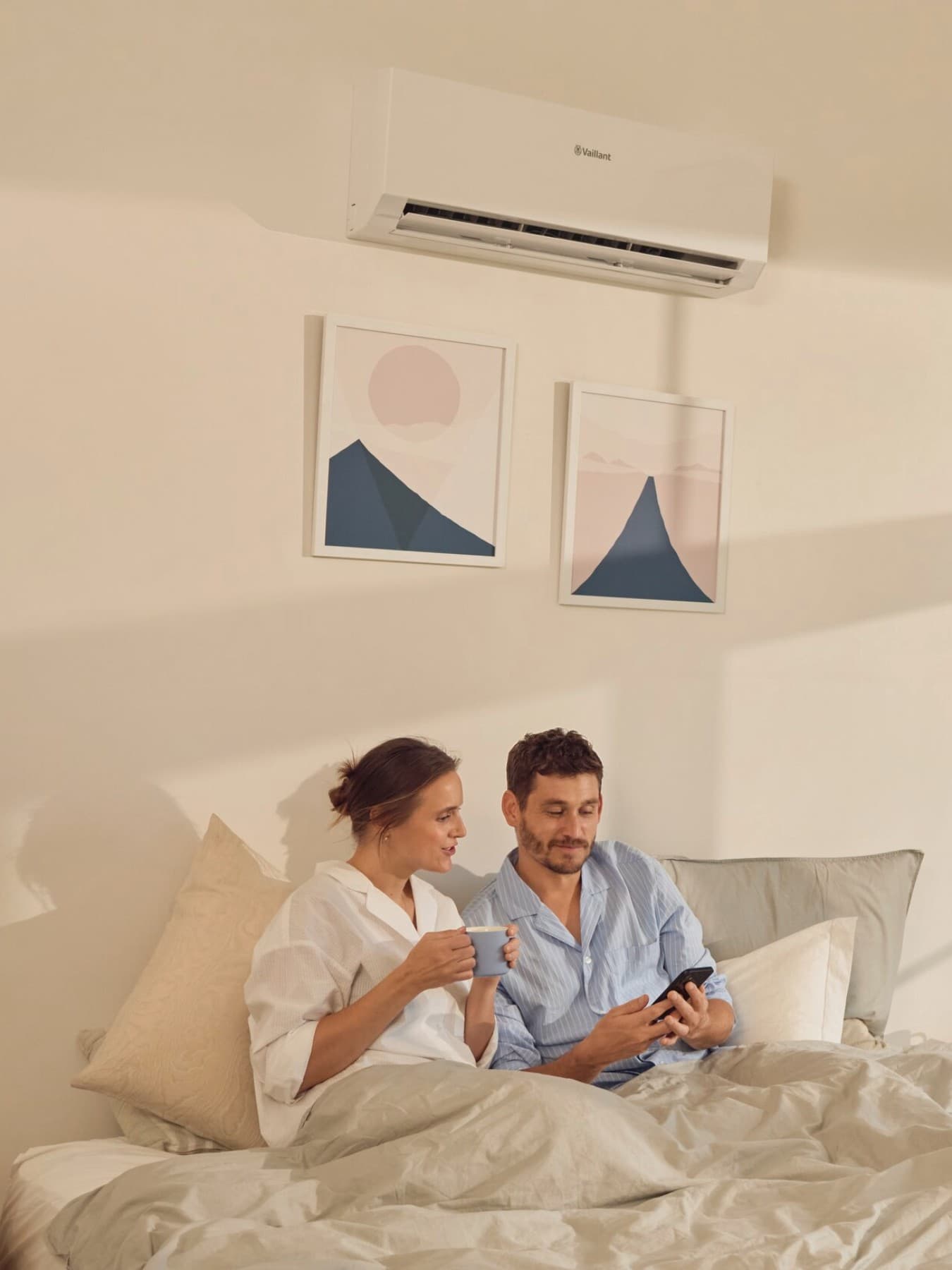 Coppia in camera da letto con unità interna del climatizzatore Vaillant installata a parete