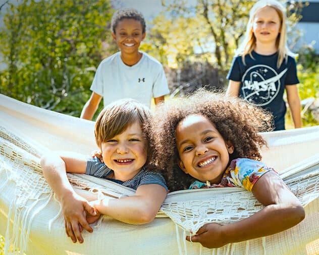 Due bambini sorridenti su un'amaca. Campagna di collaborazione Vaillant e SOS Villaggi dei Bambini