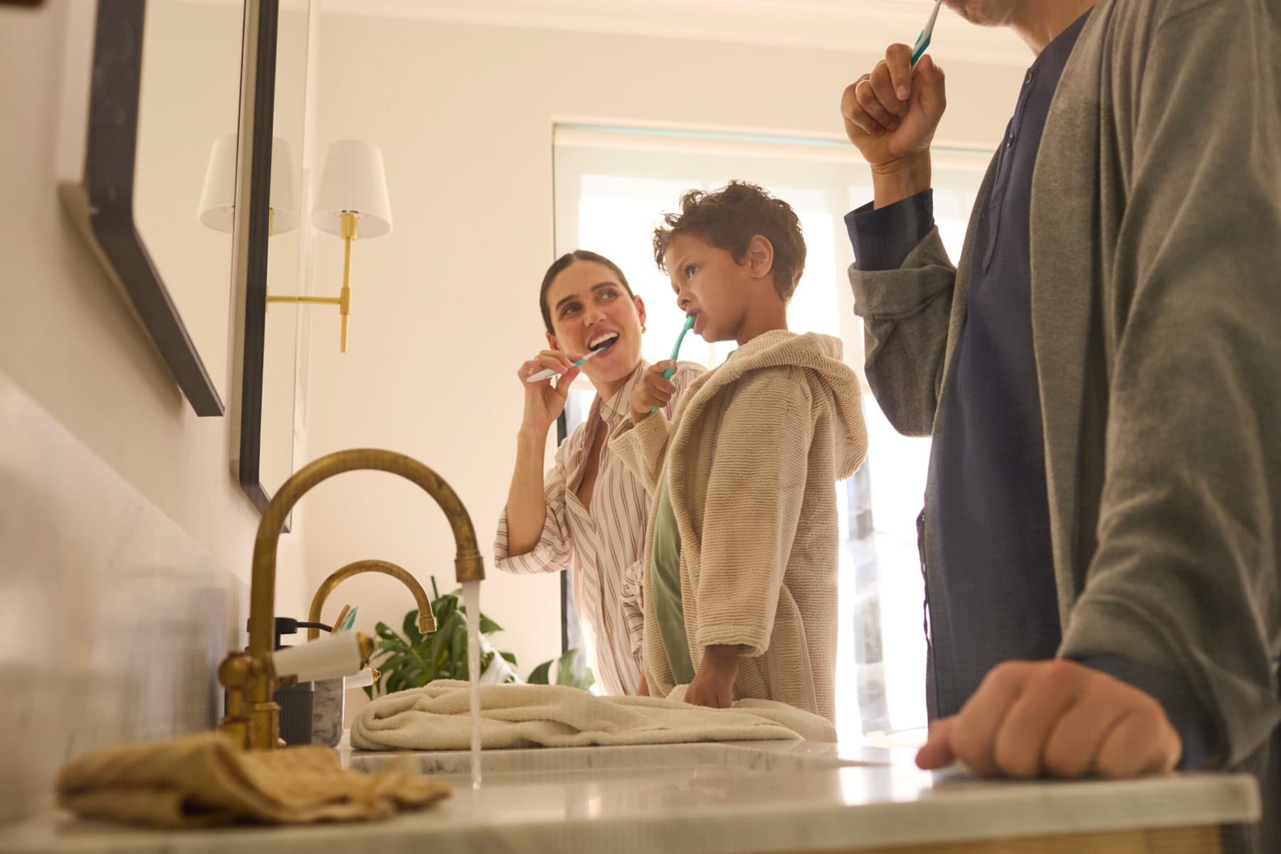 una famiglia si sta lavando i denti in bagno