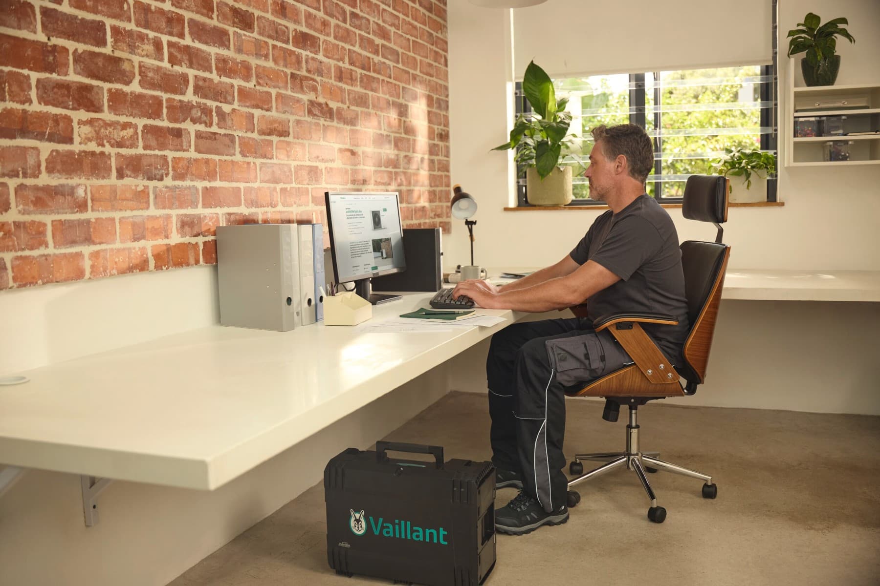 Tecnico Vaillant controlla un impianto di riscaldamento dalla sua scrivania.