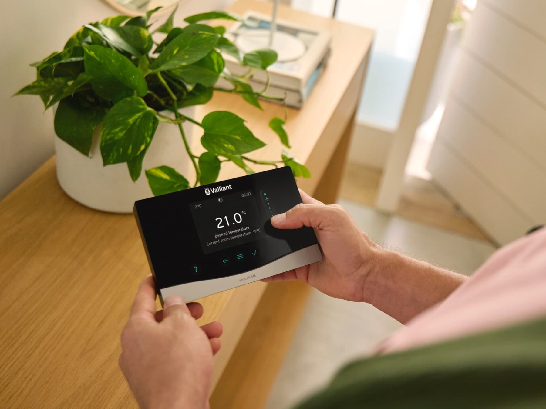 Uomo con in mano il sistema di controllo sensoCOMFORT