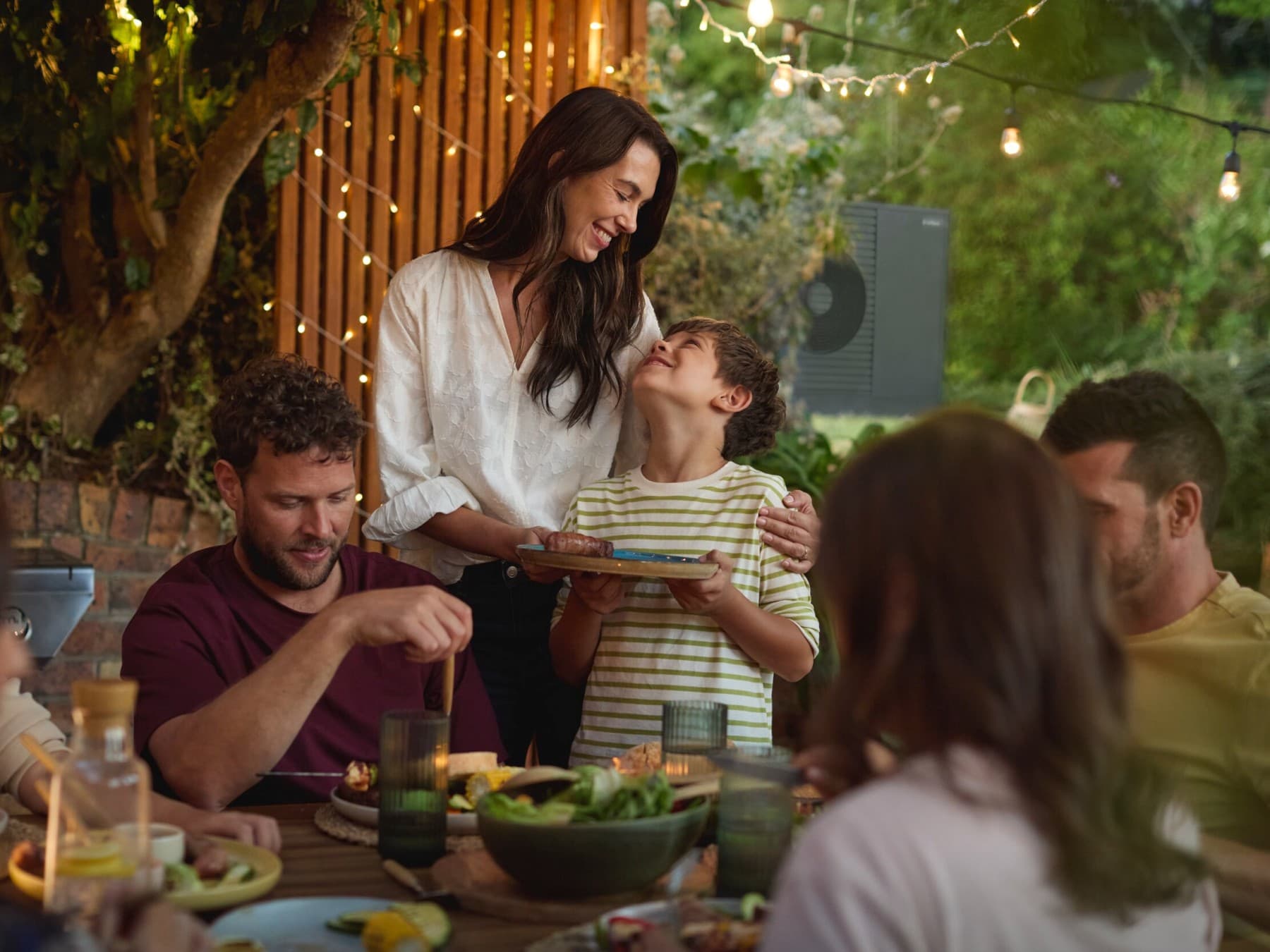 Famiglia che si gode un barbecue in giardino con gli amici