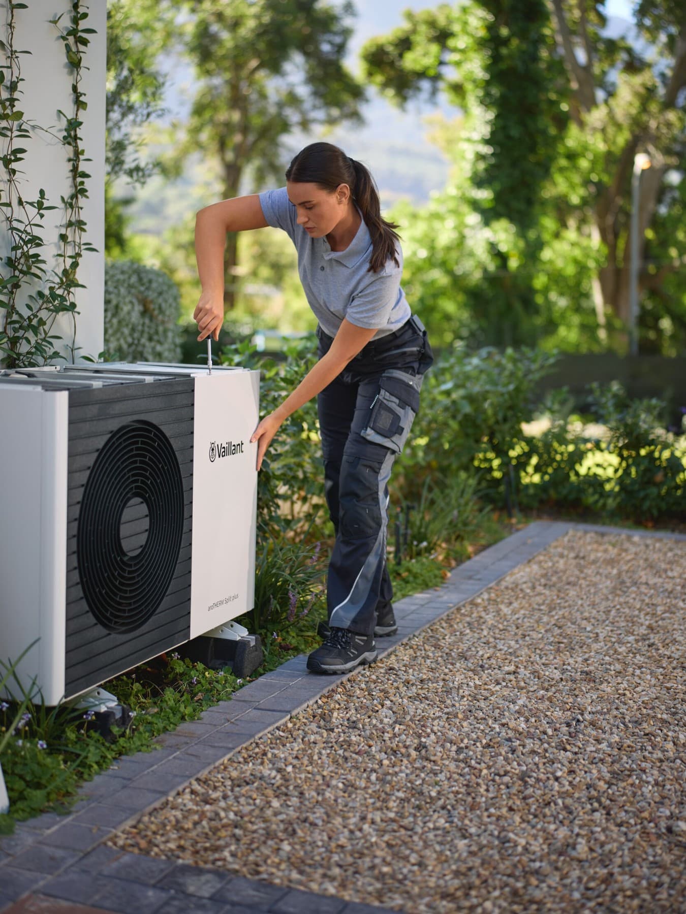 Bambino seduto sopra a una pompa di calore Vaillant.