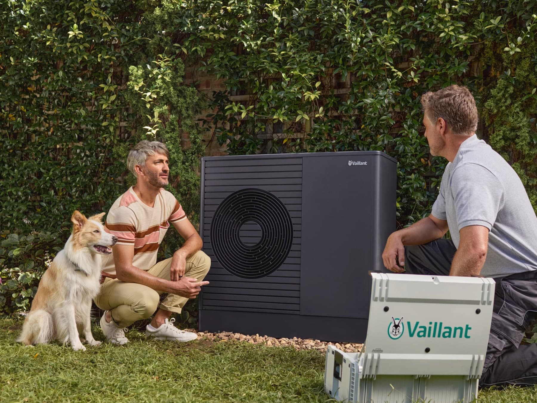 Tecnico Vaillant con cliente e il suo cane in giardino.