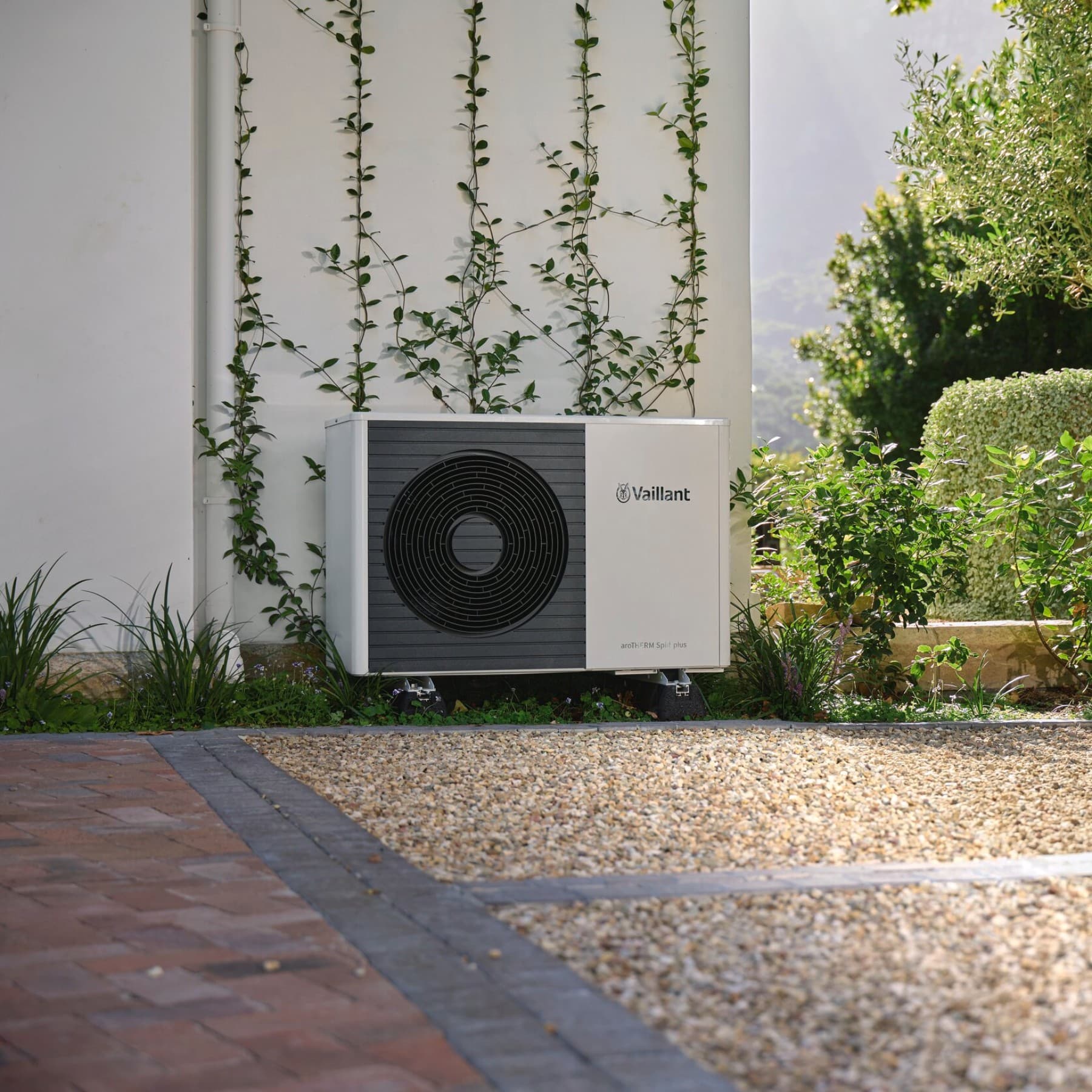 Pompa di calore Vaillant posizionata davanti a un muro nel giardino