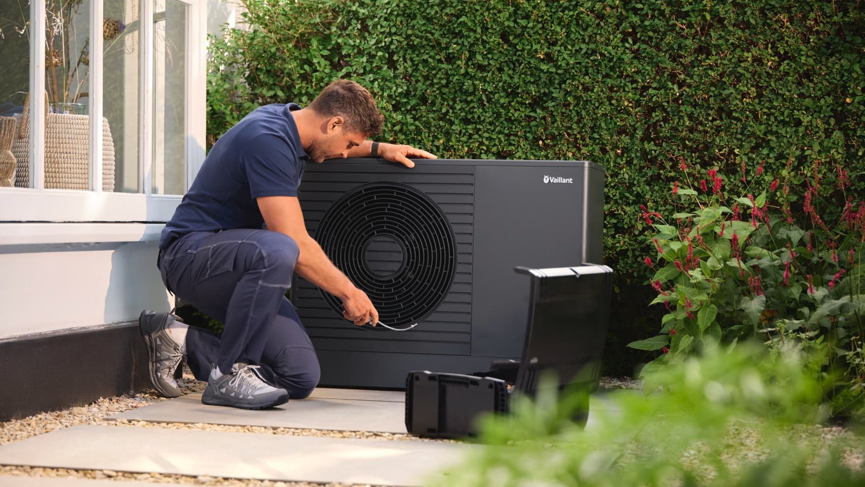 Installatore al lavoro su un'unità interna di una pompa di calore