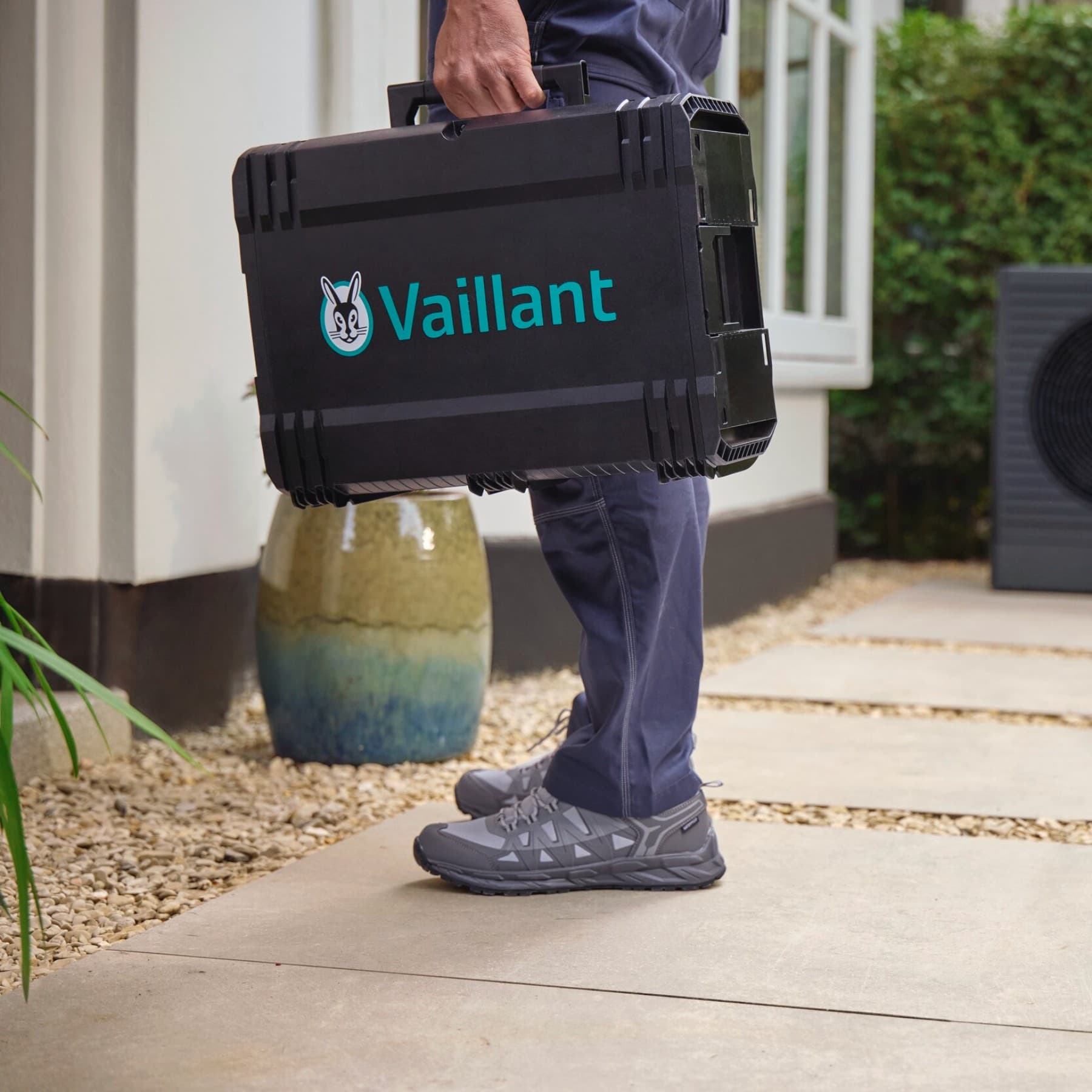 Tecnico Vaillant con valigetta Vaillant davanti alla porta di un cliente.