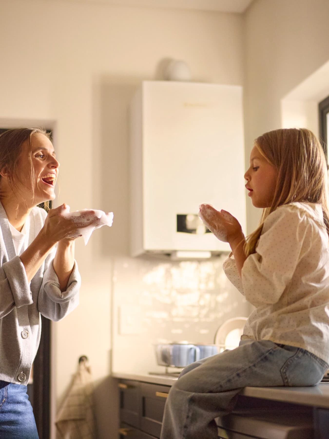 Madre e figlia davanti a una caldaia
