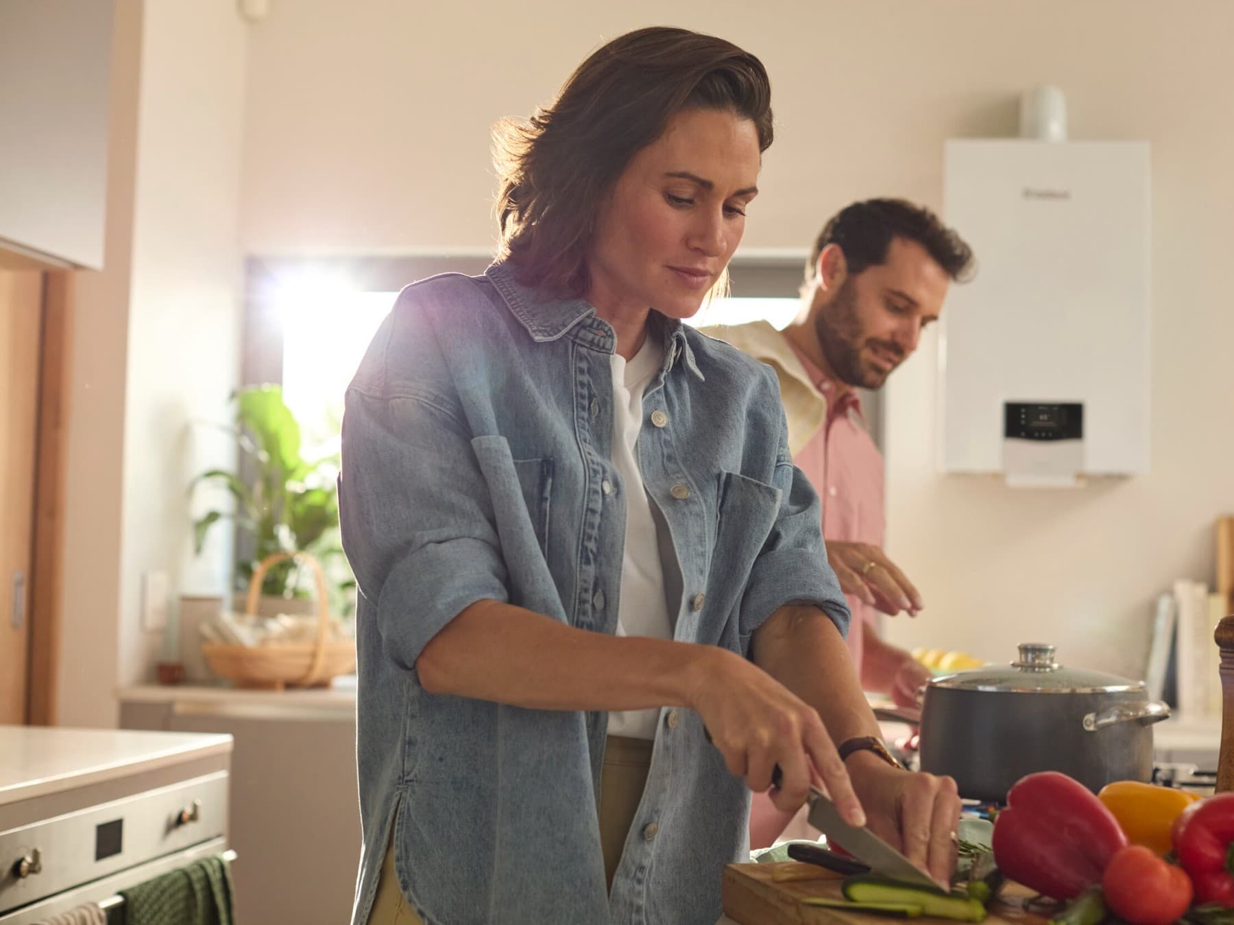Coppia cucina con alle spalle una caldaia murale Vaillant.