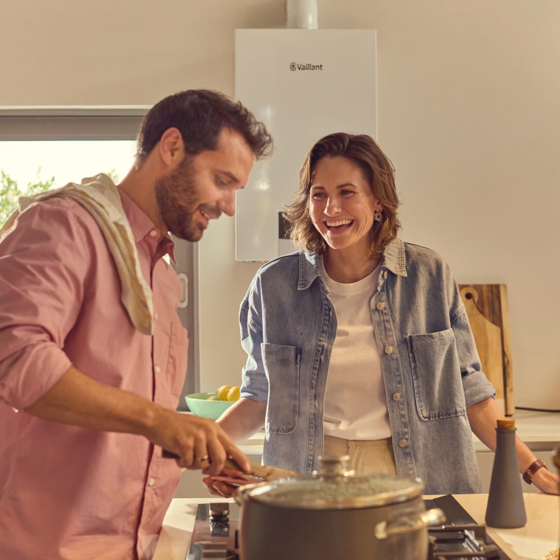 Coppia cucina il pranzo con alle spalle una caldaia ecoTEC plus Vaillant.