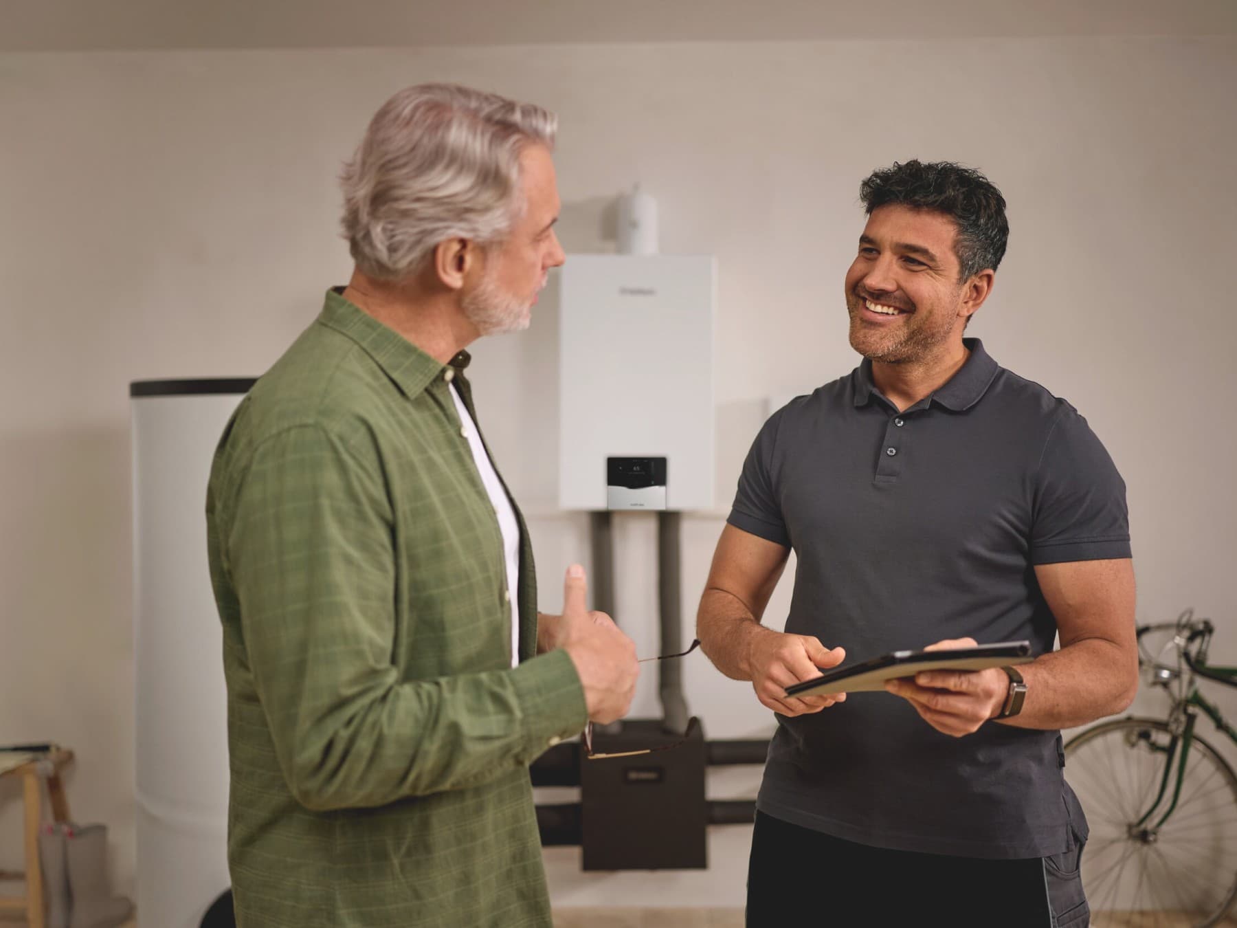 Cliente e tecnico Vaillant davanti a una caldaia e a un bollitore uniSTOR VIH R 300-500 l.